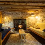 Picture showing the living room with woodburning stove and 2 large sofas