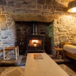 Picture showing the living room with woodburning stove and 2 large sofas