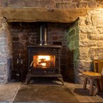 Picture showing the living room with woodburning stove and 2 large sofas