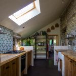 A picture of the kitchen with sink, hob cooker and shelving
